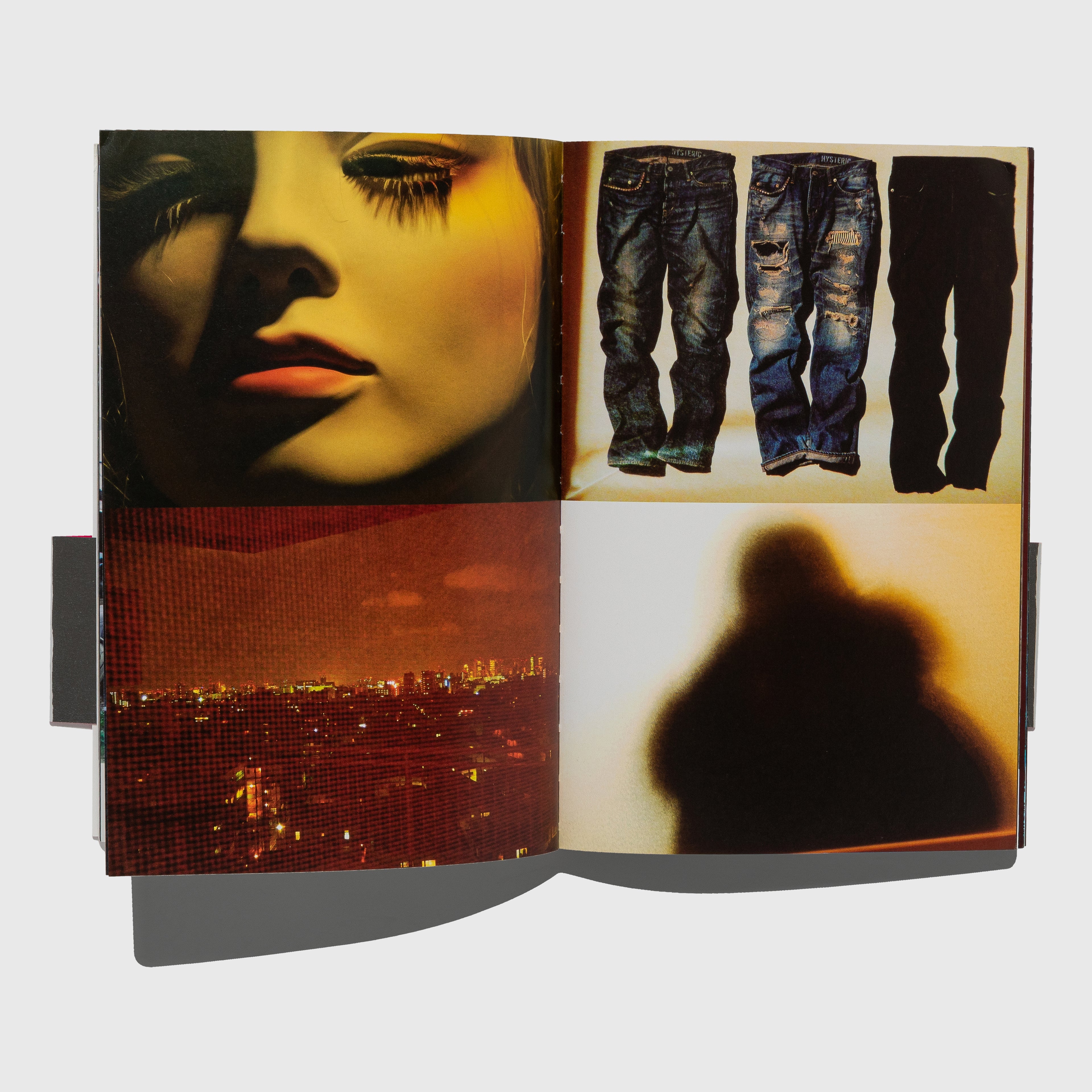 Open book with images of a face, jeans, and a cityscape. Daido Tokyo photography book by Daido Moriyama. 