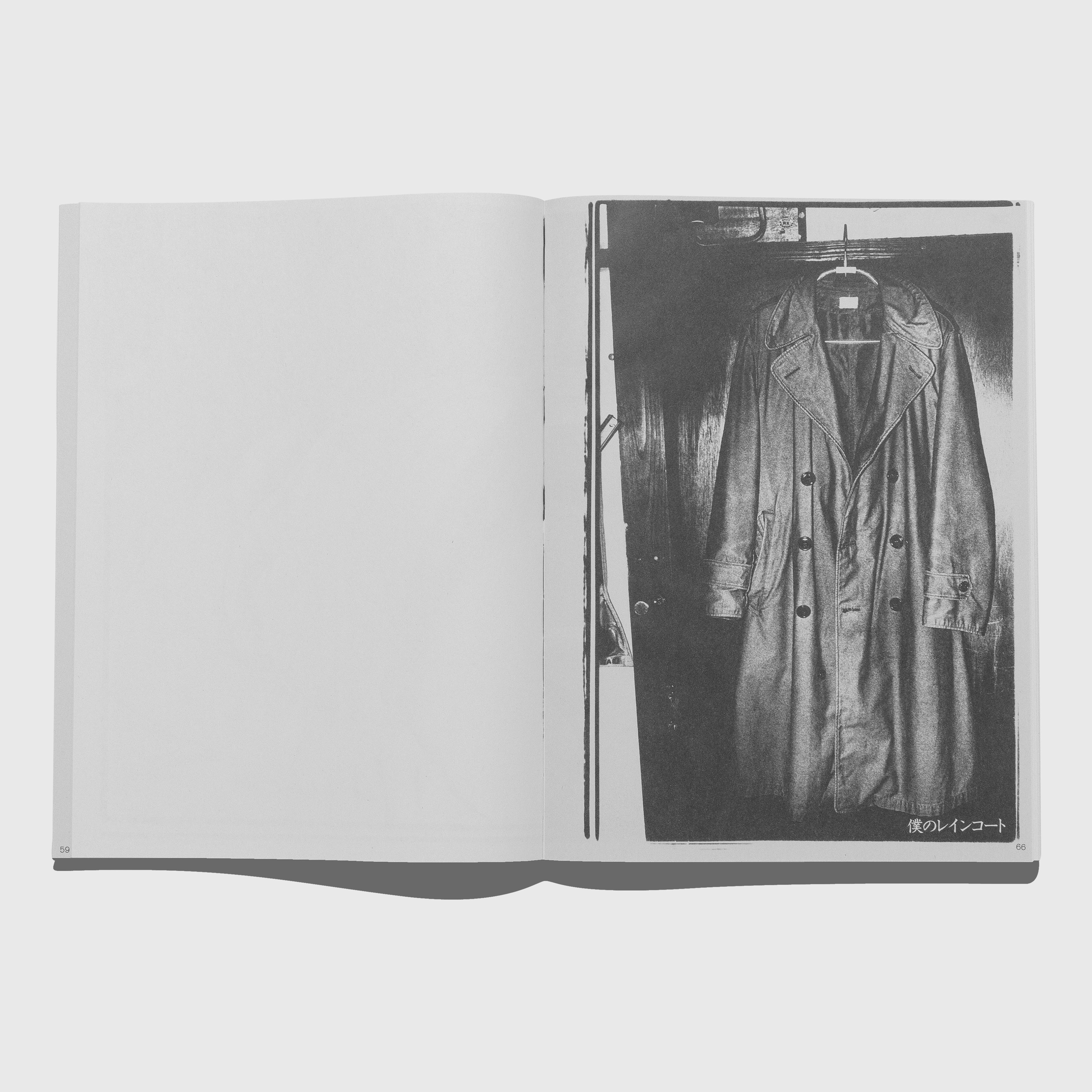 Open book showing a black and white photograph of a trench coat on a hanger. Daido Moriyama photography Shashin Jidai 1981-1988 book.