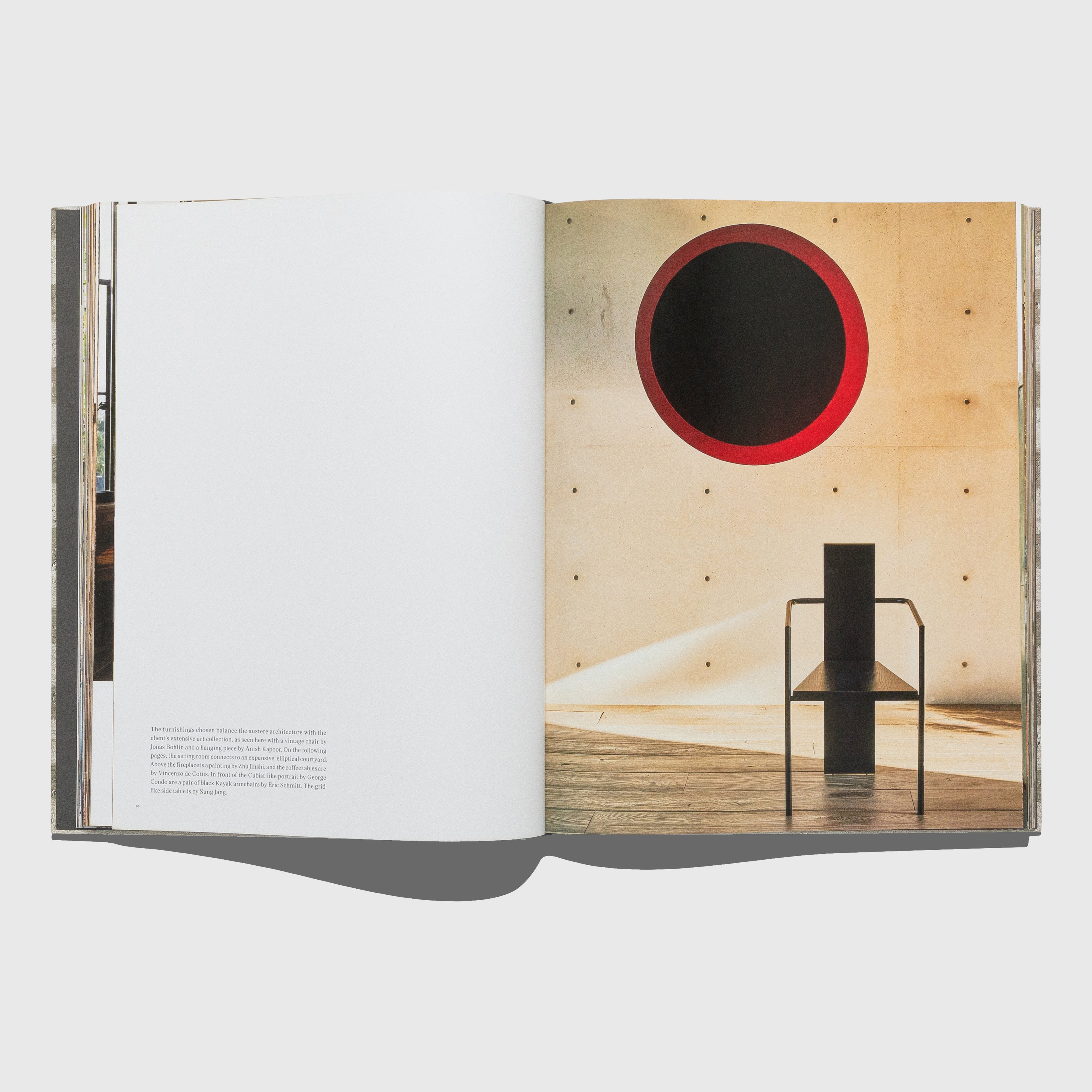 Open book showing a page with a photograph of a room with a red circular feature on the wall. Synchronicity by Kelly Wearstler. Published by Rizzoli.