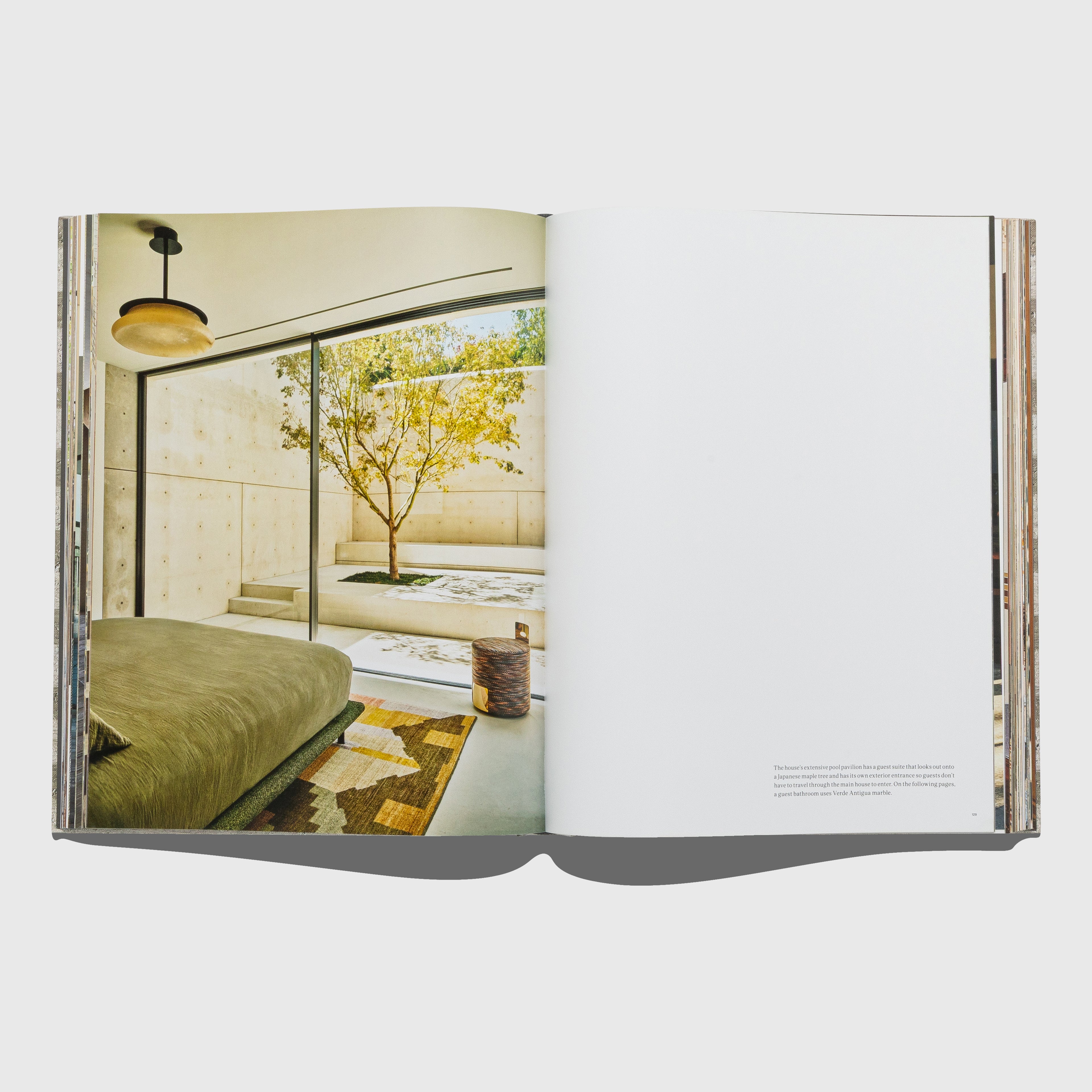 Open book showing an interior design layout with a bedroom and living area. Synchronicity by Kelly Wearstler. Published by Rizzoli.