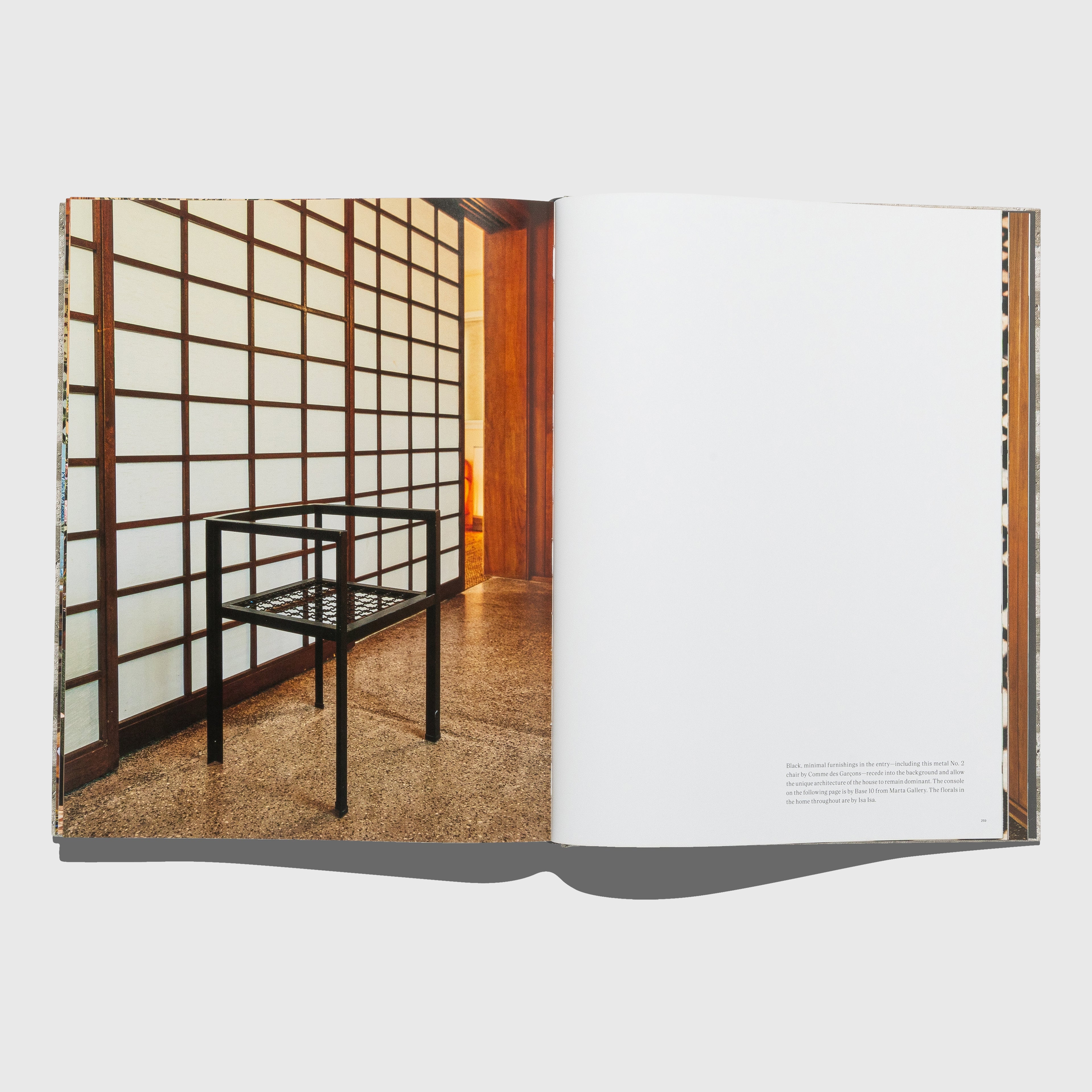 Open book showing a room with a shoji screen and wooden floor. Comme Des Garçons chair. Synchronicity by Kelly Wearstler. Published by Rizzoli.