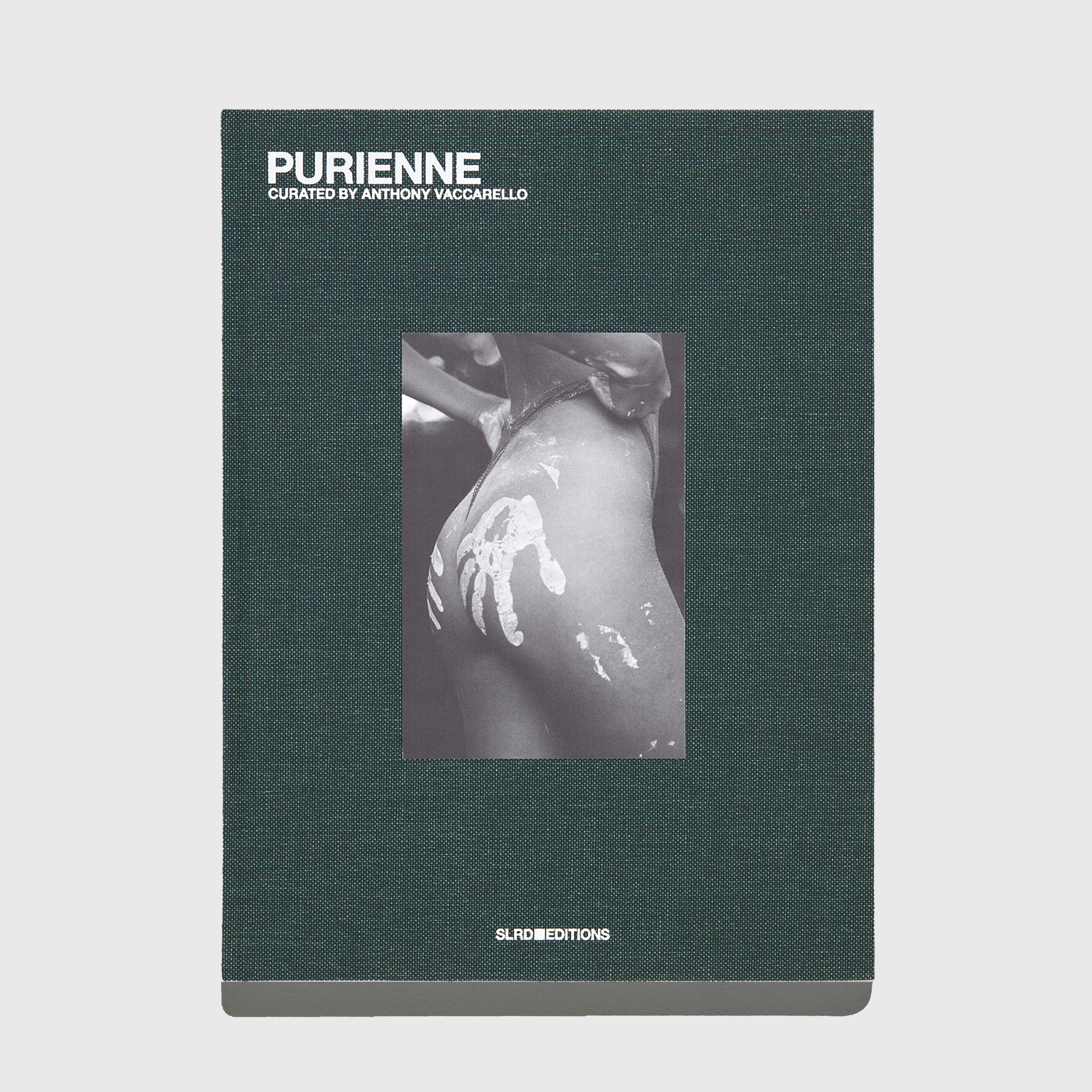 Book titled 'Purienne' curated by Anthony Vaccarello for YSL SL Editions with a dark green cover and black and white photo