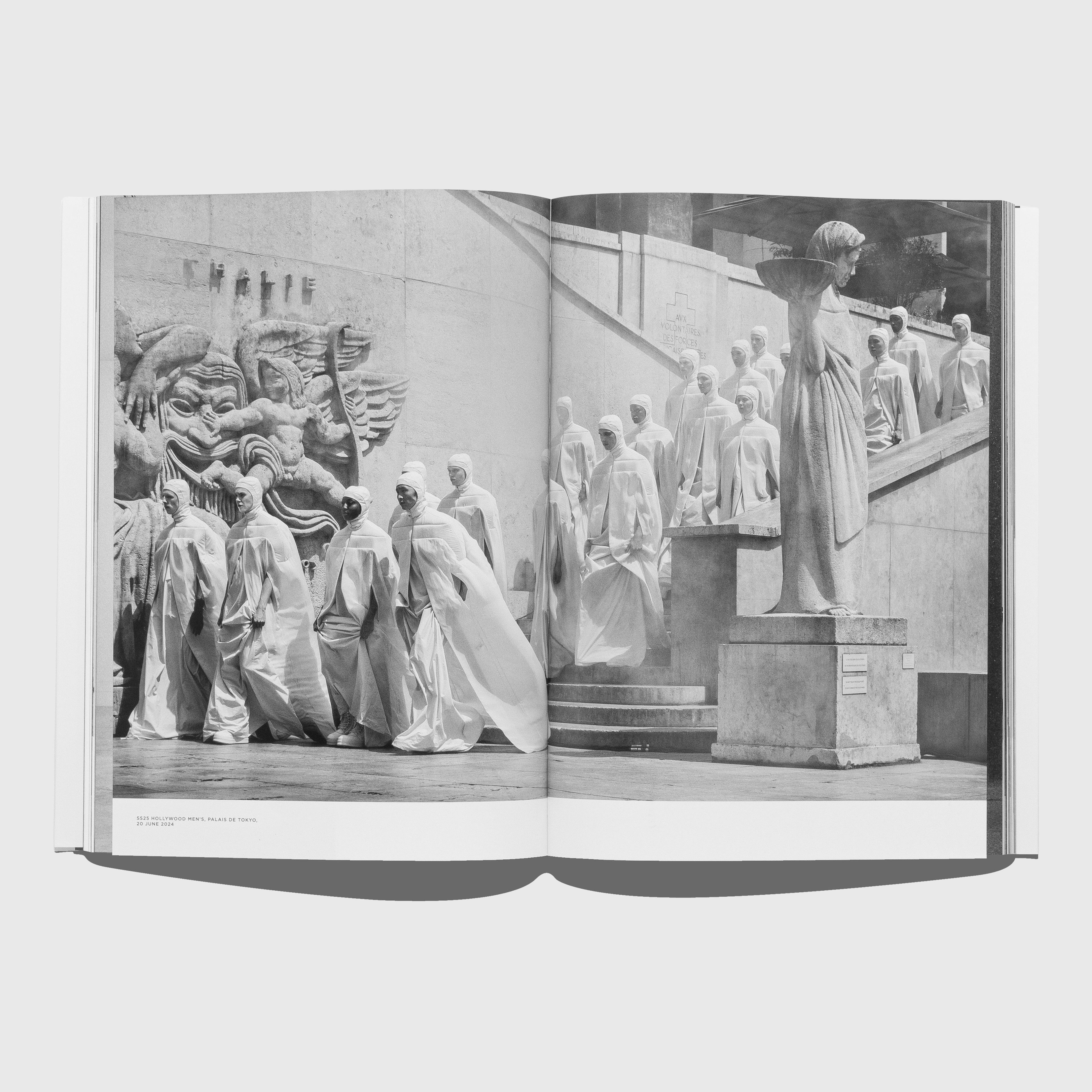 Open book showing a black and white photograph of statues and architecture. Rick Owens Temple of Love book. Published by Rizzoli and Palais Galleria.