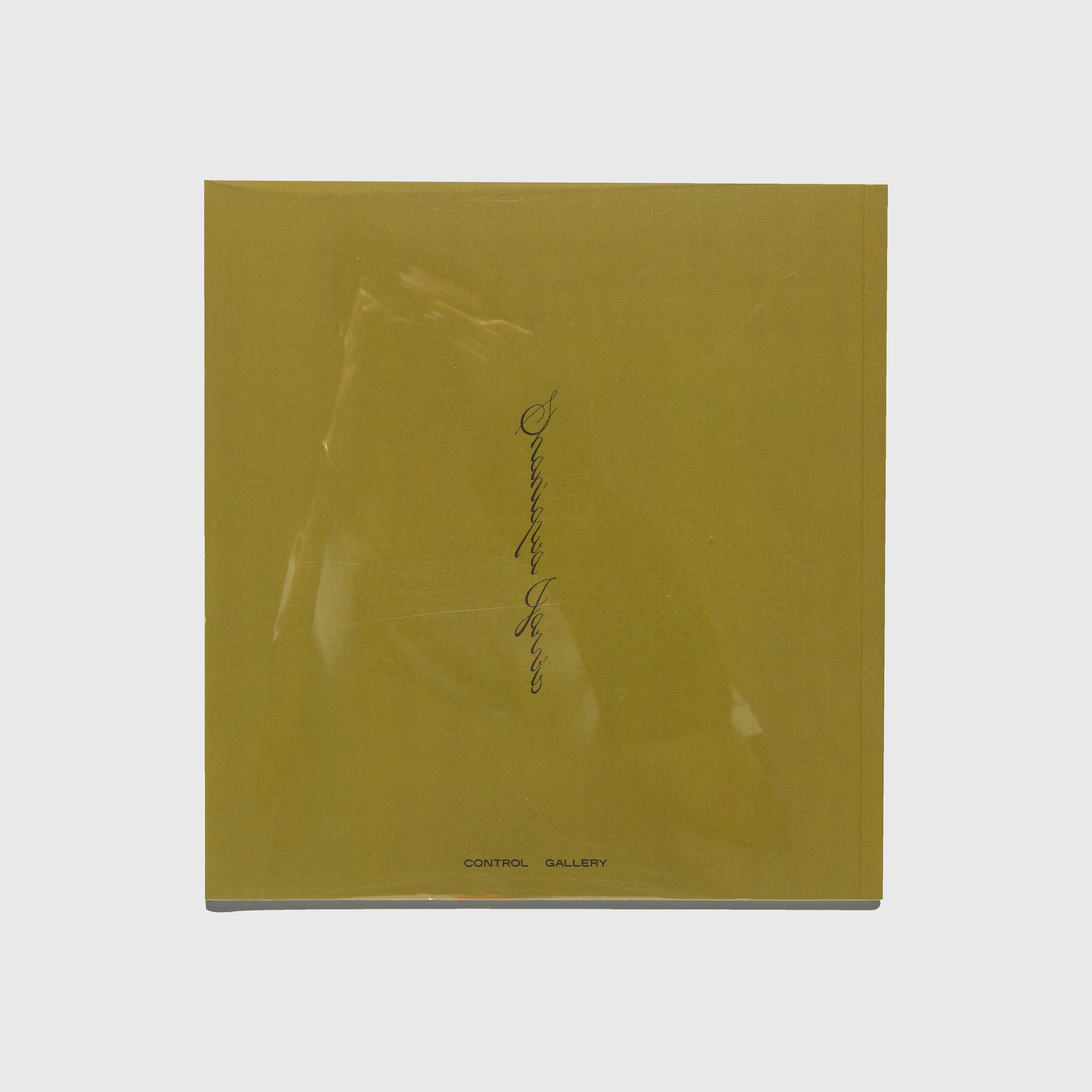 Yellow book with a signature on a white background. Shaniqwa Jarvis.