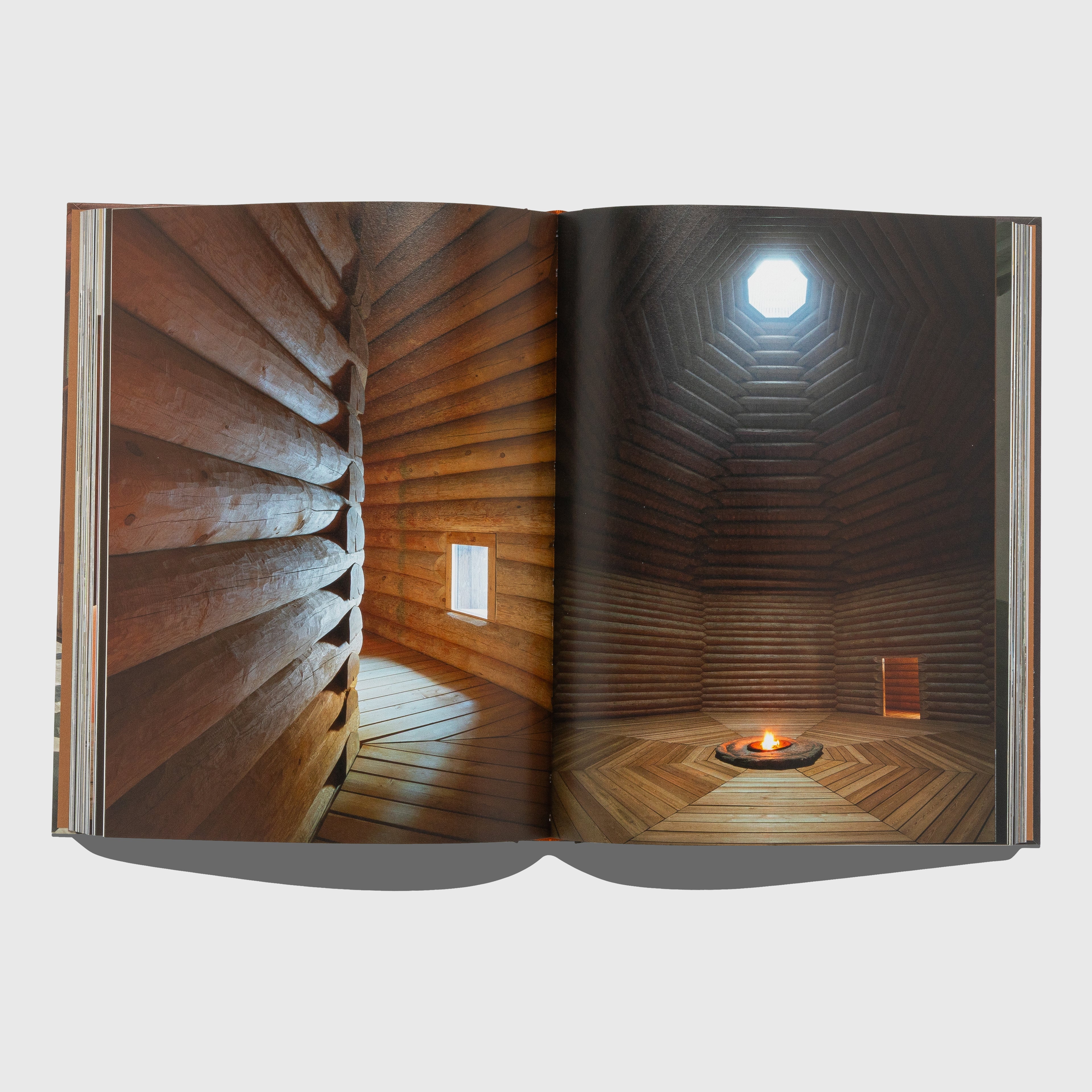 Open book showing a wooden interior design with a light fixture. Portraits of Interiors by Axel Vervoordt published by Flammarion.