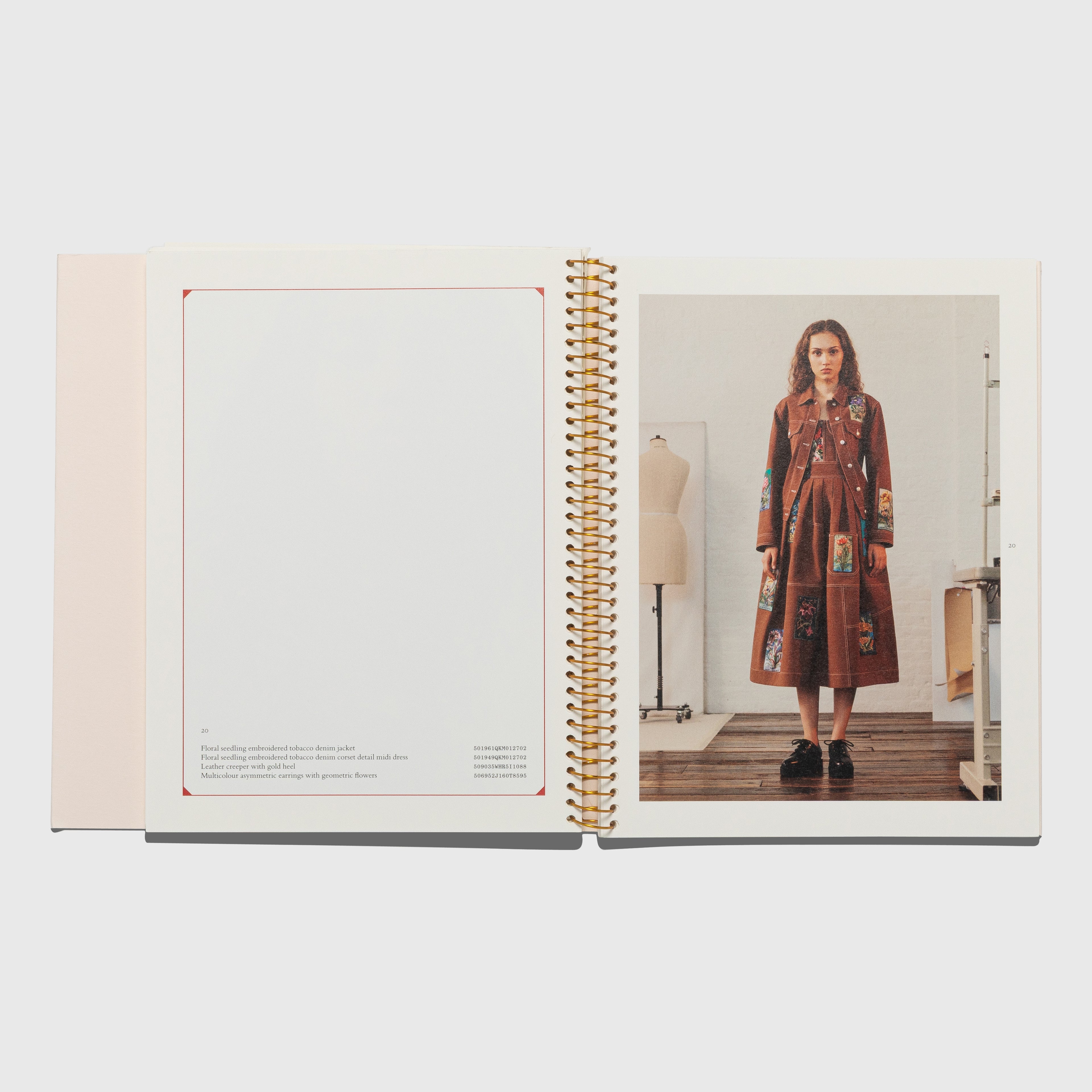 Open book showing a page with a model wearing a patterned dress in a room. Alexander McQueen spring summer 2018 catalog