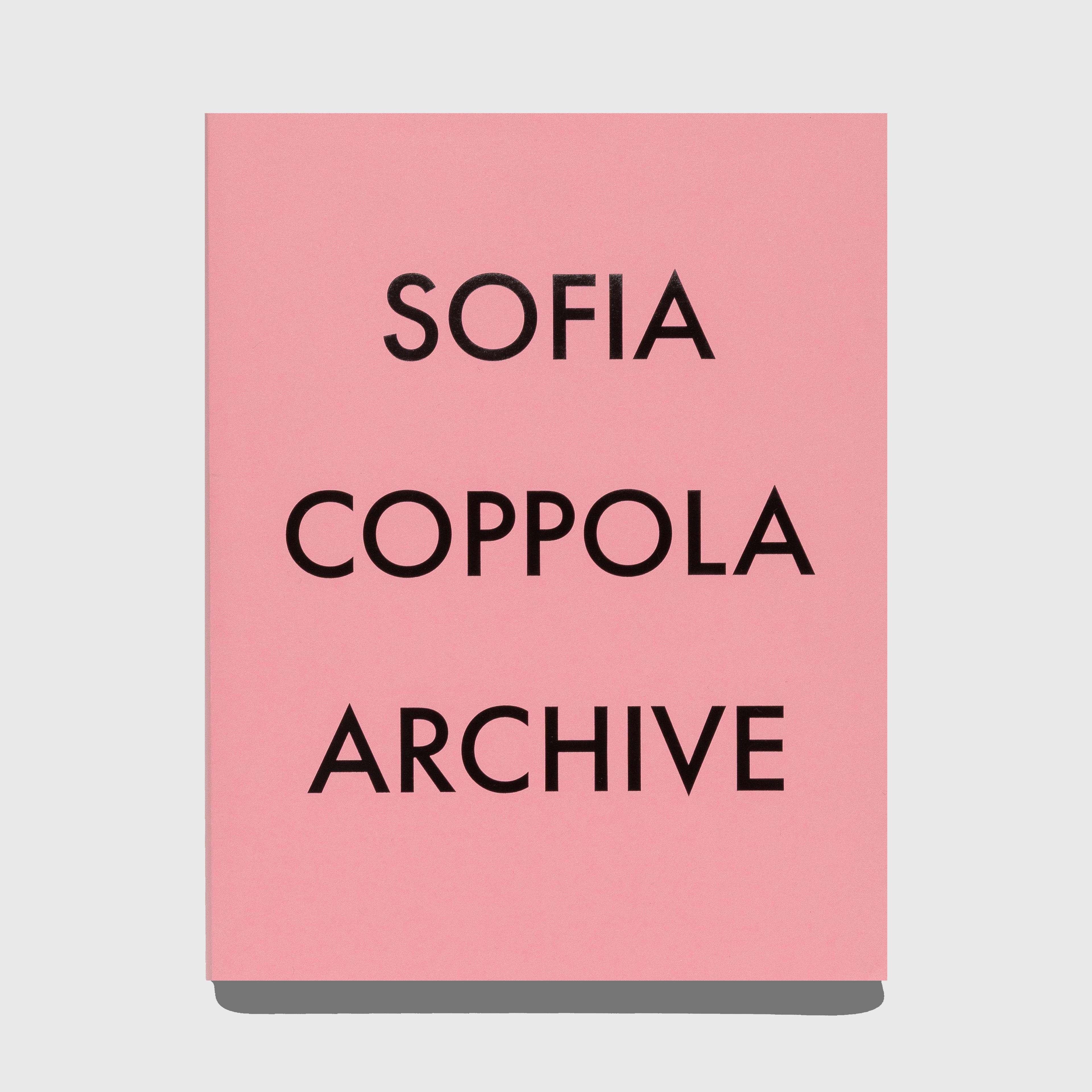 Pink book or cover with 'Sofia Coppola Archive' text on a gray background